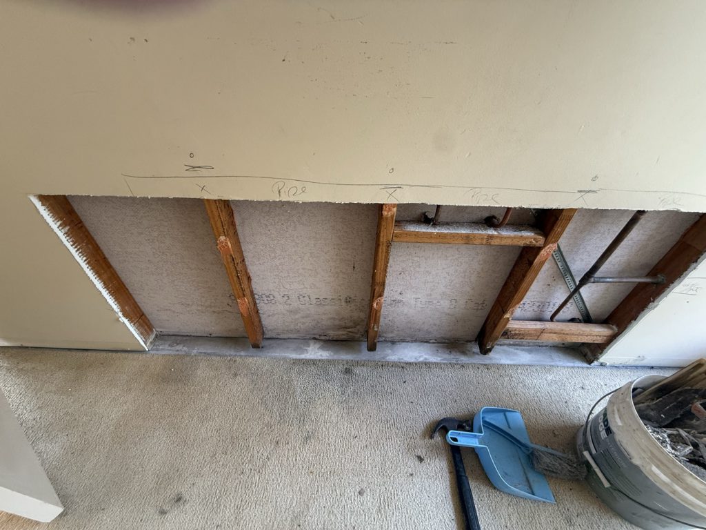 Open wall showing timber framing during repair